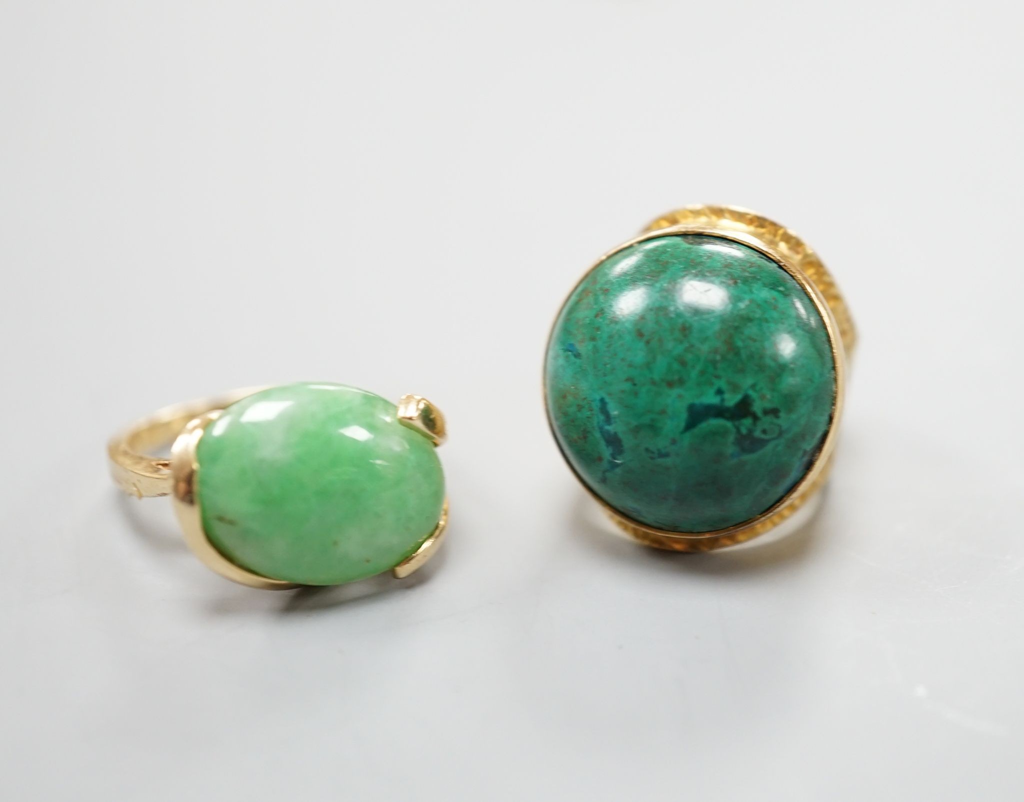 A modern 14k yellow metal and cabochon malachite set dress ring, size F and a similar cabochon jade set ring, size K, gross weight 16.8 grams.